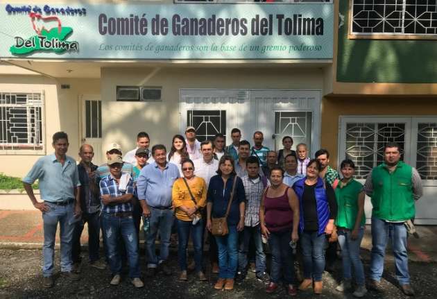 Grupo de personas frente a la sede del Comité de Ganaderos del Tolima, en un encuentro del gremio ganadero con el letrero institucional visible en la fachada